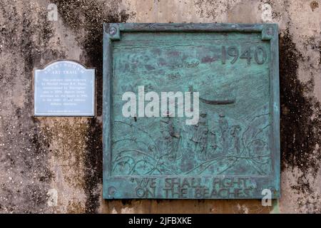 Sheringham, UK - May 16th 2022: Sculptured plaque, located promenade in the seaside town of Sheringham in Norfolk, UK, depicting family activities on Stock Photo