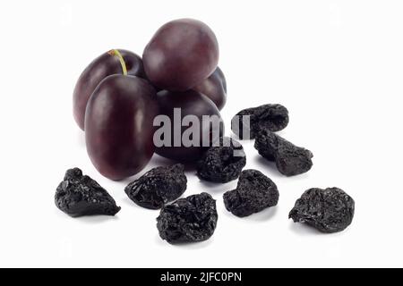 Fresh and dried plums isolated on bright background. Close up view. Stock Photo