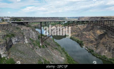 A view of a bridge over the river between the canyons in daytime Stock Photo