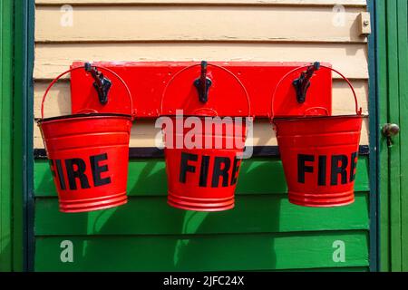 Three vintage fire buckets at Pickering Railway Station in North Yorkshire, UK. Stock Photo