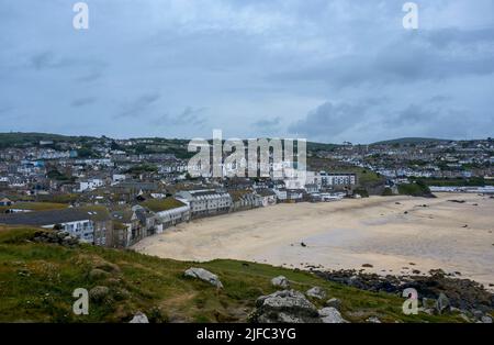 An almost deserted Porthmeor Beach, showing beachfront houses and Tate St Ives, taken from the top of 'The Island' or 'St Ives Head', Cornwall Stock Photo