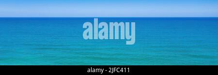 Seascape minimal panoramic background. Clear sky, horizon over blue waves Stock Photo