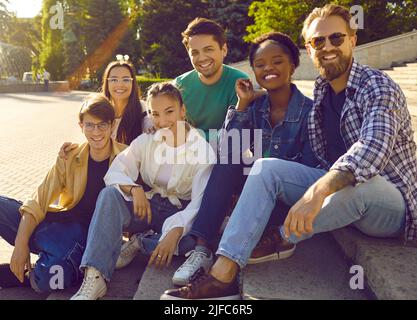 Portrait of carefree cheerful and friendly multiracial men and women on background of city park. Stock Photo