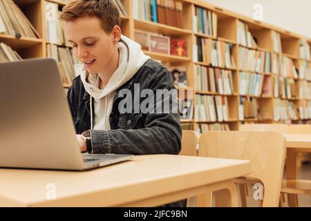 Smiling student preparing for exams in college library Stock Photo