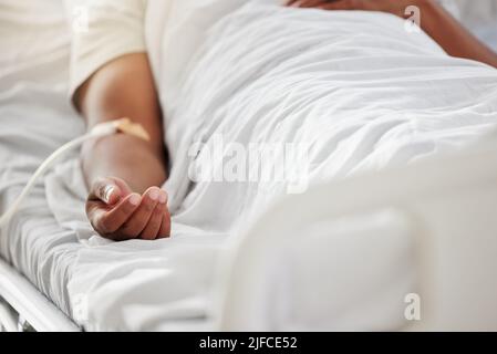 Close up of a sick male patient lying in hospital bed with saline drip in arm. Close up of a sick male patient lying in hospital bed with saline drip Stock Photo