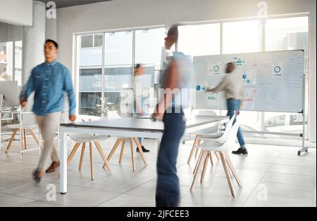 Group of diverse businesspeople walking around in a busy office at work. Business professionals rushing while working together in an office. Four Stock Photo