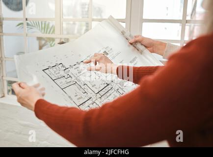 Hands of businesspeople holding a blueprint. Closeup of architect holding a building plan. Two colleagues collaborate on building project. Engineers Stock Photo