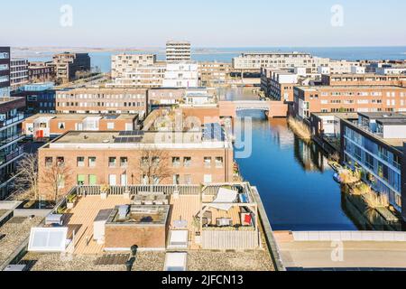 Panoramic view of the city, high-rise and brick houses, water surface and blue sky Stock Photo