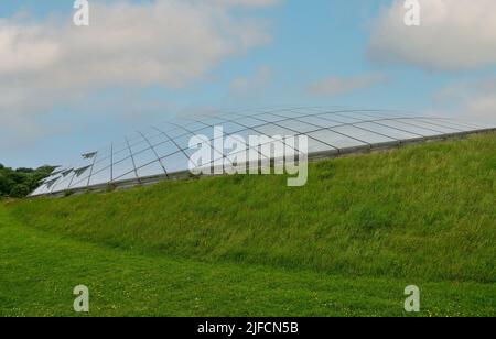 Futuristic conservatory dome of glass panels in steel joists, set into a hillside. Wales Botanic Garden world's largest single span glasshouse Stock Photo