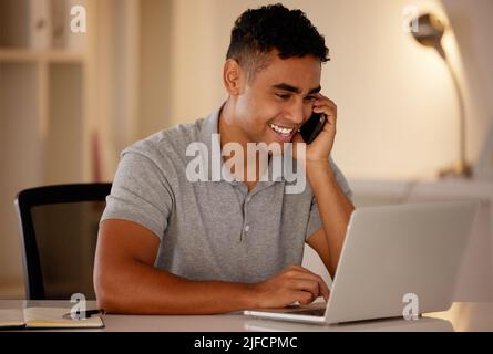 One young mixed race business man multitasking by talking on a cellphone and using a laptop to browse the internet. Happy, ambitious entrepreneur Stock Photo