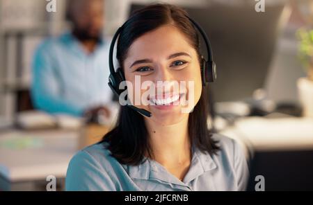 Portrait of one happy young smiling caucasian call centre telemarketing agent talking on headset in office. Face of confident and friendly Stock Photo