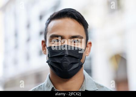 Man wearing a face mask while out in the city. Man wearing a face mask while out in the city. Stock Photo