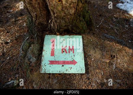 A sign indicating the length of the tourist route 1 kilometer lying on ...