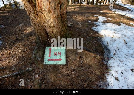 A sign indicating the length of the tourist route 1 kilometer lying on ...