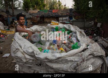 Kashmir, India. 01st July, 2022. (220702) -- SRINAGAR, July 2, 2022 (Xinhua) -- A ragpicker puts plastic bottles in a sack bag in Srinagar, summer capital of Indian-controlled Kashmir, July 1, 2022. The Indian government set up dedicated control rooms and form special enforcement teams to check illegal manufacture, import, stocking, distribution, sale and use of banned single-use plastic (SUP) items. All states and territories in the country have been asked to set up border checkpoints to stop inter-state movement of any banned SUP items, said an official announcement, which reiterated a compl Stock Photo