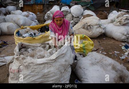 Kashmir, India. 01st July, 2022. (220702) -- SRINAGAR, July 2, 2022 (Xinhua) -- A ragpicker puts polythene items in a sack bag in Srinagar, summer capital of Indian-controlled Kashmir, July 1, 2022. The Indian government set up dedicated control rooms and form special enforcement teams to check illegal manufacture, import, stocking, distribution, sale and use of banned single-use plastic (SUP) items. All states and territories in the country have been asked to set up border checkpoints to stop inter-state movement of any banned SUP items, said an official announcement, which reiterated a compl Stock Photo