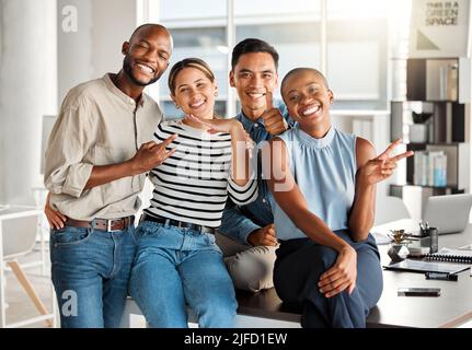 Portrait of a group of diverse cheerful businesspeople making hand gestures and spending time in an office together at work. Joyful business Stock Photo