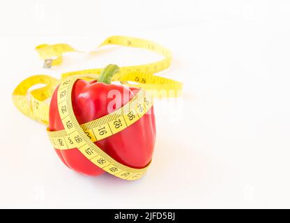 Yellow tape measure and sweet pepper on white background. Healthy lifestyle concept Stock Photo