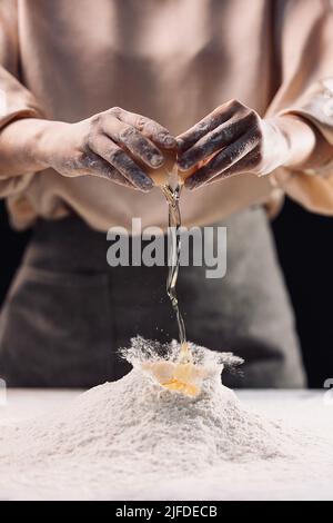 Adding eggs to flour, the traditional Chinese pasta wheaten food making process - stock photo Stock Photo