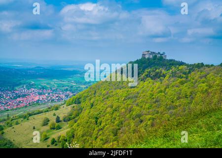 Germany, Hohenneuffen castle ruins on top of a forested mountain in foggy nature landscape atmoshpere in springtime with sun, aerial panorama view abo Stock Photo