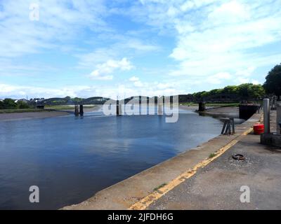 Kirkcudbright, Scotland, looking up river towards the bridge from the quayside (2022). This 5 spanned  concrete bridge over the River Dee at Kirkcudbright was built in 1926 by the engineers Mouchel. It replaced similar arched bridge  made of wrought iron  with six spans  built in 1868.  The present bridge has retained the original  ornate lamp columns . Stock Photo