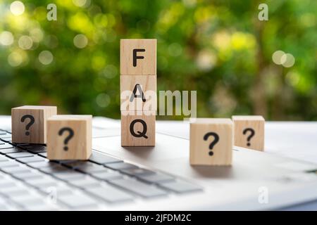 FAQ - Frequently ask question on a wood blocks with question marks Stock Photo