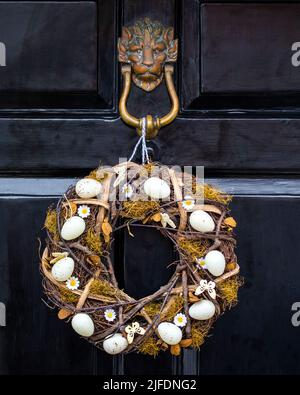 An Easter wreath hanging on a front door of a house. Stock Photo
