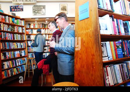 An adult man shops for books amongst the many shelves at San Francisco's City Lights Bookstore, made famous by Jack Kerouac and Allen Ginsburg Stock Photo