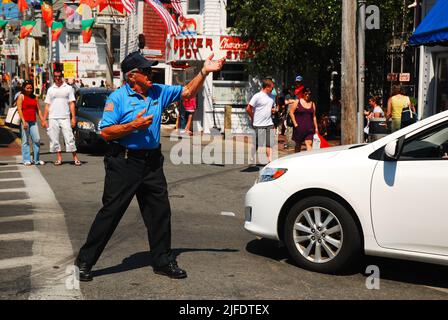 the Dancing Cop, A traffic police officer directs cars safely through a busy intersection during the hectic summer season in Provincetown, Cape Cod Stock Photo