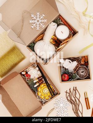 Making Christmas kits for meditation, relaxation and self-care. Holiday card with gift boxes with candles, aroma sticks, natural oils and decorations. Stock Photo