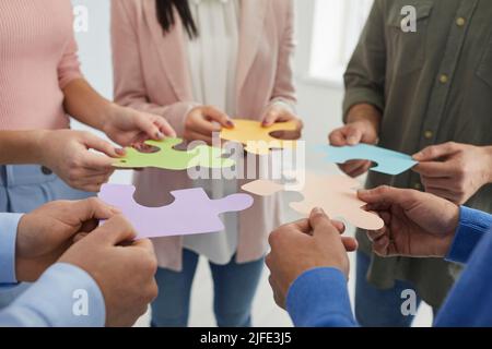 People holding colored pieces of puzzles symbolizing development and successful completion of tasks. Stock Photo
