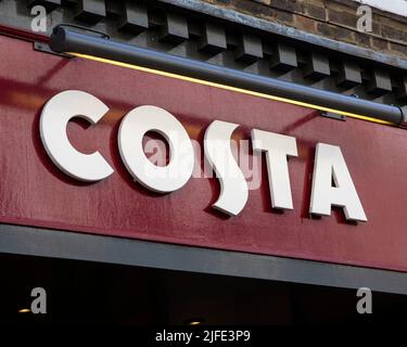 Norfolk, UK - April 8th 2022: Close-up of the Costa logo above the entrance to their coffee shop in the market town of Kings Lynn in Norfolk, UK. Stock Photo