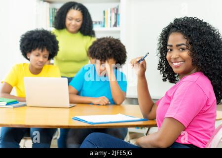 Pretty african american computer science student with group of coding students at university Stock Photo