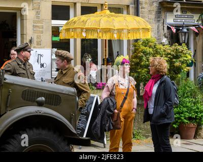 1940's nostalgic living history re-enactment weekend (men in WW2 costume, people in conversation) - Haworth Main Street, West Yorkshire, England UK. Stock Photo