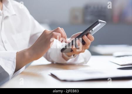 Close-up photo of female hands using the phone, business woman at work. Stock Photo