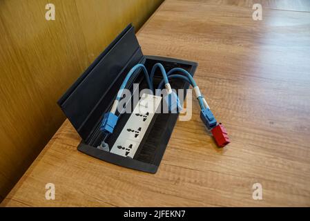 Female LAN connectors on the wooden table. LAN cables on the table. Stock Photo