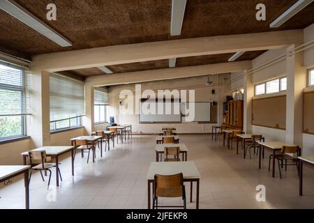 Empty classroom with desks far apart Stock Photo