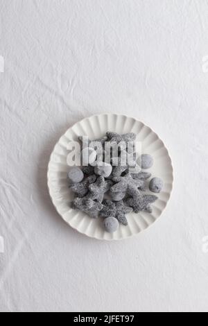 Salty liquorice salmiakki in Finnish in a white plate top view Stock Photo