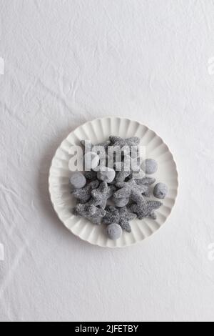 Salty liquorice salmiakki in Finnish in a white plate top view Stock Photo