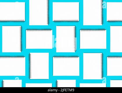 Pattern background made from spiral notebooks on blue Stock Photo