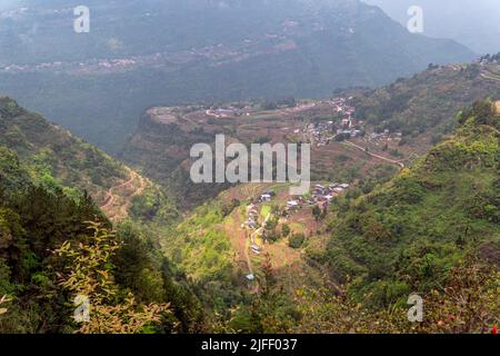 Aerial view of a rural village surrounded by lush green fields and ...