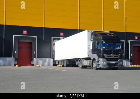 Unloading trucks in a modern warehouse complex. Transportation, storage, logistics. Stock Photo