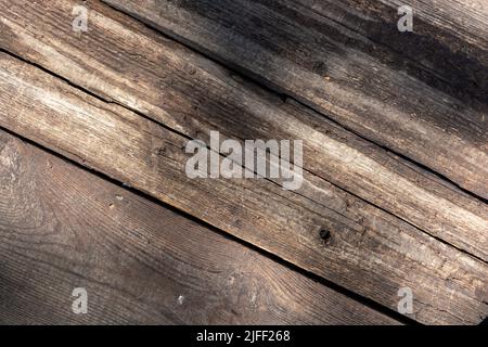 Old rotten boards placed diagonally with sun glare.Vintage backdrop Stock Photo
