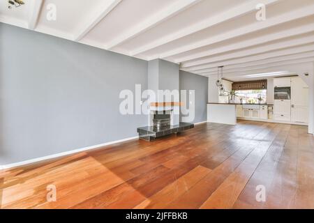 Interior of a spacious bright room with an fireplace and an elegant chandelier in the kitchen area Stock Photo