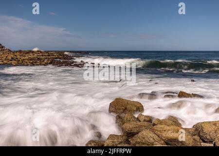 Long exposure landscape - silky sea water washing into rocks and breaking waves in Clovelly, Randwick, Sydney, on the Australian coast. Stock Photo