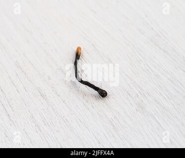 Close up of match used on a white wooden background Stock Photo
