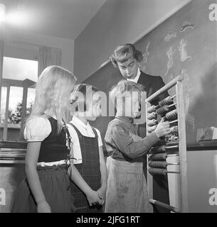 School in the 1950s. The female schoolteacher watches as her first grade pupils are learning how to count. Sweden 1952 Kristoffersson ref  BH11-11 Stock Photo