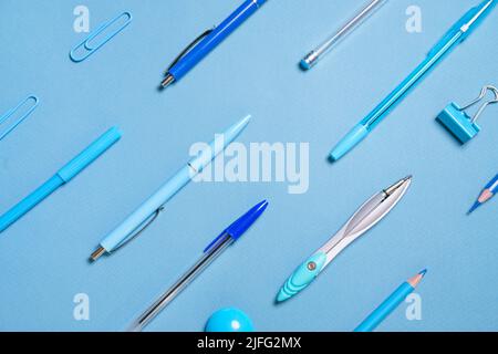 Pens pencils compasses paper clips laid out in lines all blue and background, concept for school stationery items and for business Stock Photo