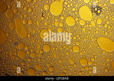 Yellow oil drops on the water surface Stock Photo