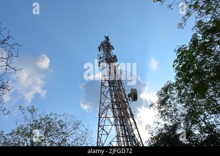 Horana,Kalutara District,Sri Lanka March 20 2022:Low angle view of a red and white communication tower with lots of antennas under a cloudy sky Stock Photo